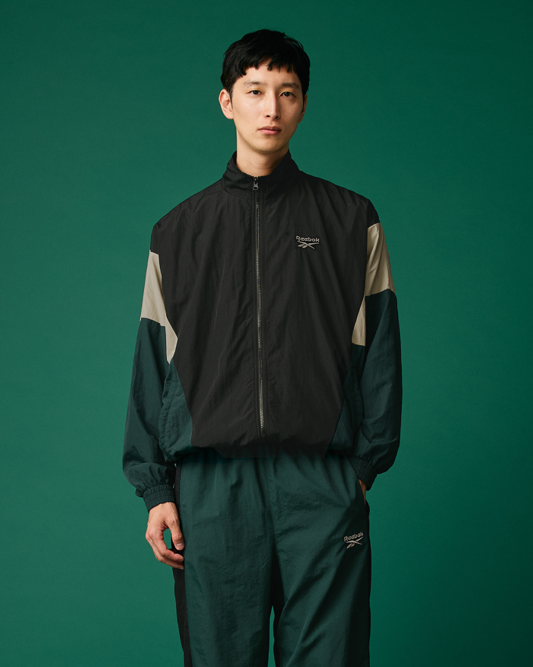 ブラックとグリーンのセットアップを着用したメンズルック